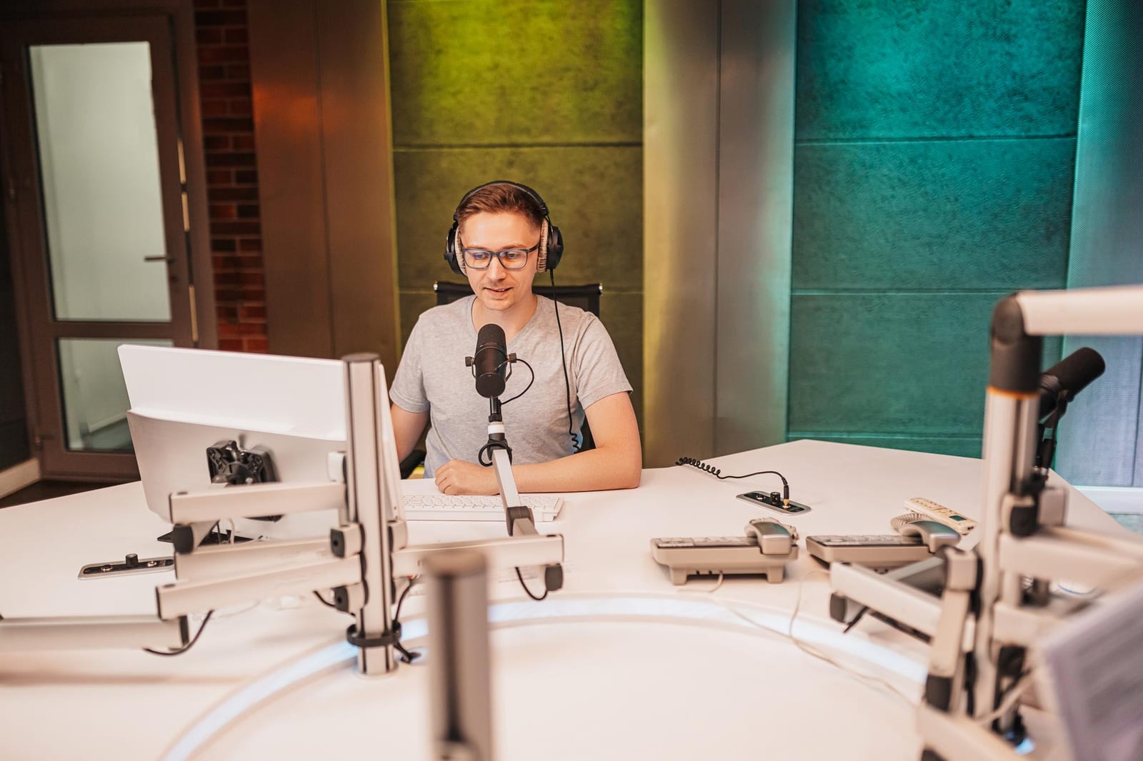A radio host speaking into a microphone while recording an episode