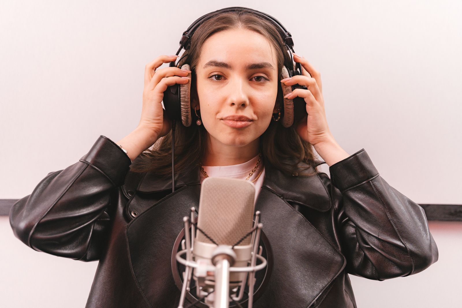 A podcast host recording an episode at a small studio desk with a microphone